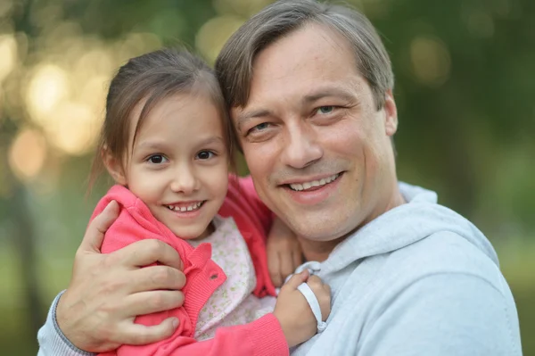 Отец обнимает свою маленькую дочь на природе — стоковое фото