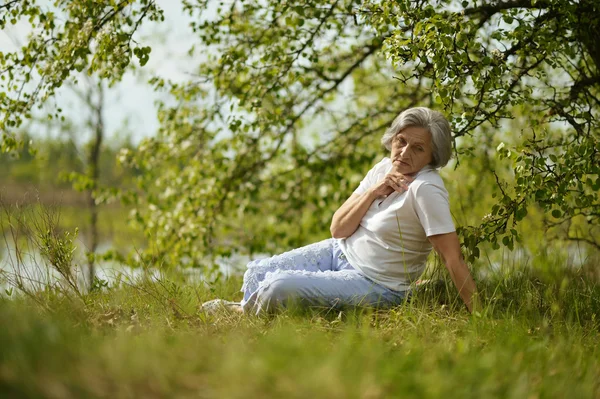 Thinking old woman in the autumn park — Stock Photo, Image