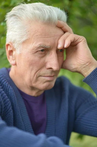 Pensive elderly man resting in a park — Stock Photo, Image