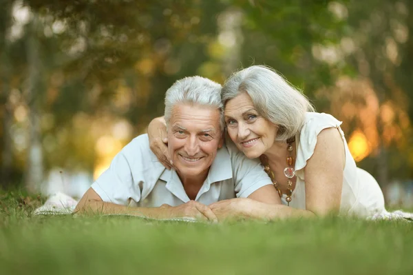 Pareja de ancianos acostados en la hierba —  Fotos de Stock