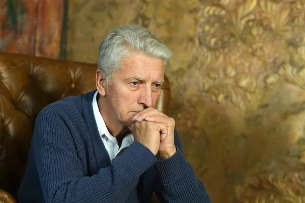 Senior man sitting in a couch — Stock Photo, Image