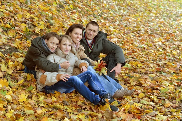 Familia sentada en el parque de otoño — Foto de Stock