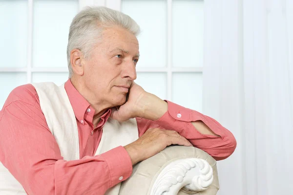 Senior man sitting in a couch — Stock Photo, Image
