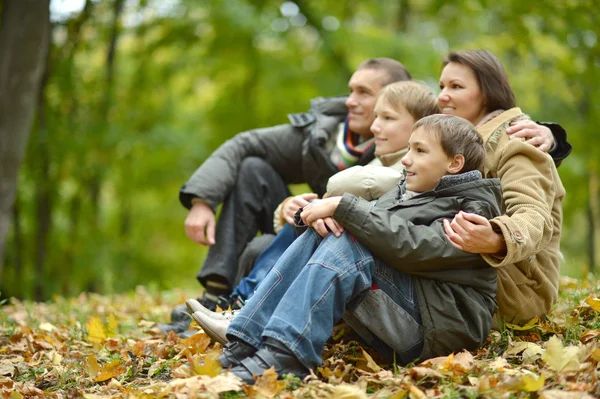 Familie sitzt im Herbstpark — Stockfoto