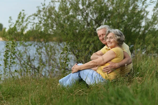 Seniorenpaar sitzt am See — Stockfoto