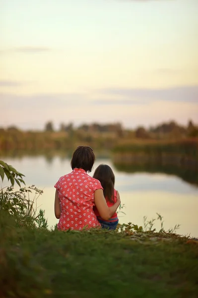 Bambina con madre vicino al lago — Foto Stock