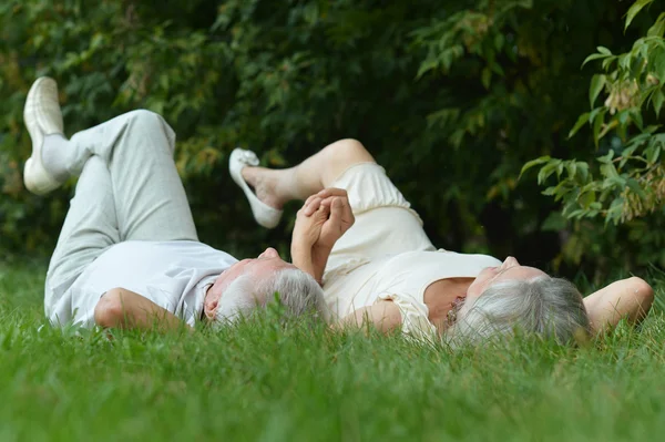 Старая пара лежит на траве — стоковое фото