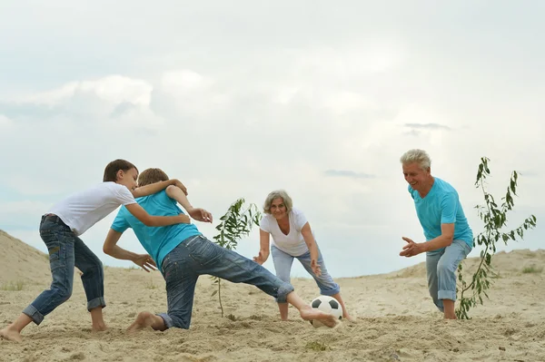 Familia jugando al fútbol en una playa —  Fotos de Stock