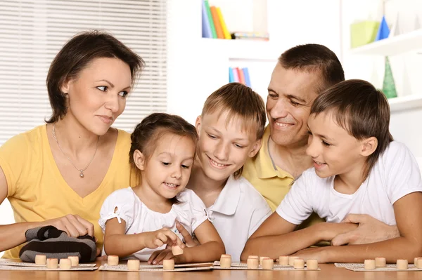 Leuke familie aan tafel spelen — Stockfoto