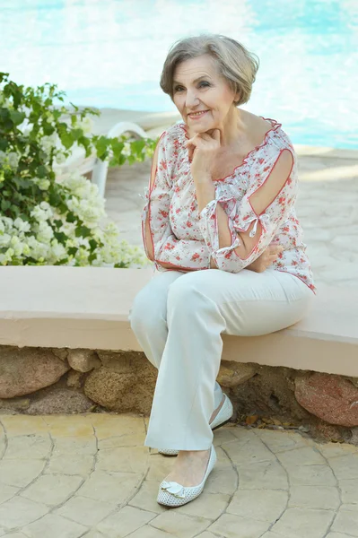 Elderly woman with flowers — Stock Photo, Image