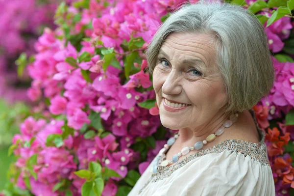 Older woman with flowers — Stock Photo, Image