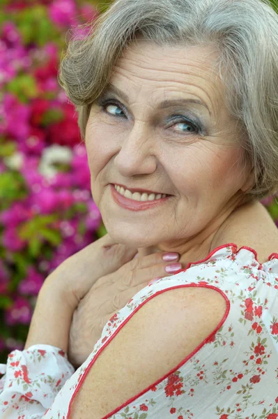 Elderly woman with flowers — Stock Photo, Image