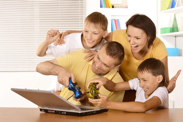 Perhe pelaa kannettavalla tietokoneella — kuvapankkivalokuva
