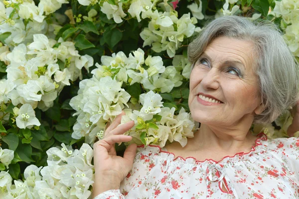 高齢者の女性の花を持つ — ストック写真
