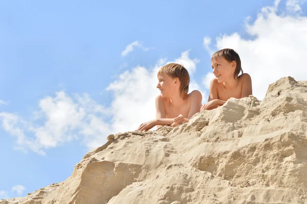 Boys sitting on sand hill — Stock Photo, Image