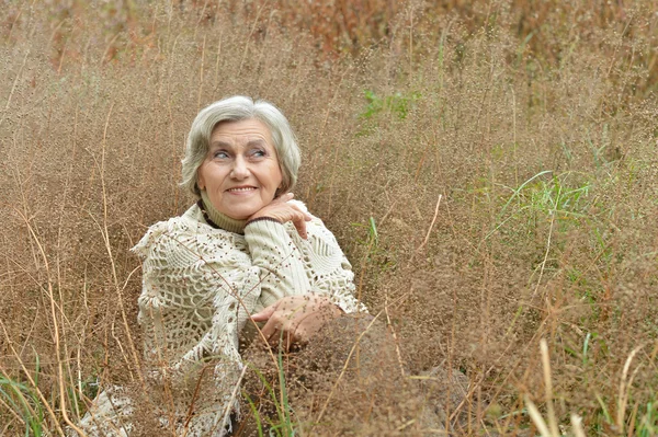 Kvinde sidder på græs - Stock-foto