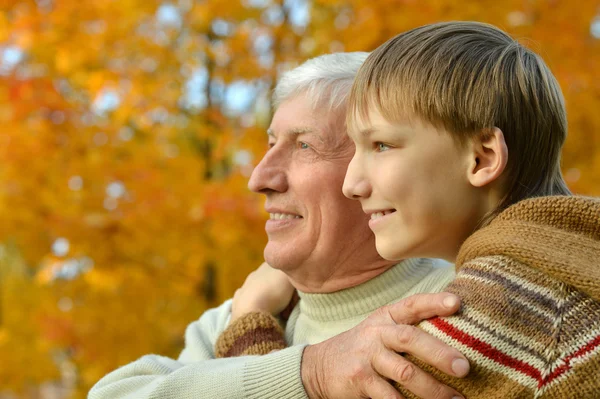 Nonno con ragazzo nel parco autunnale — Foto Stock