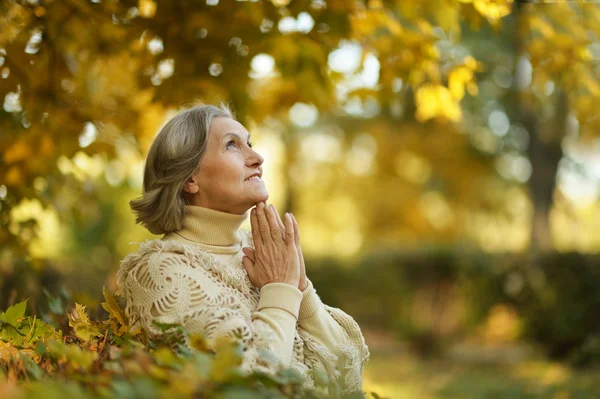 Nadenkend bejaarde vrouw in herfst park — Stockfoto