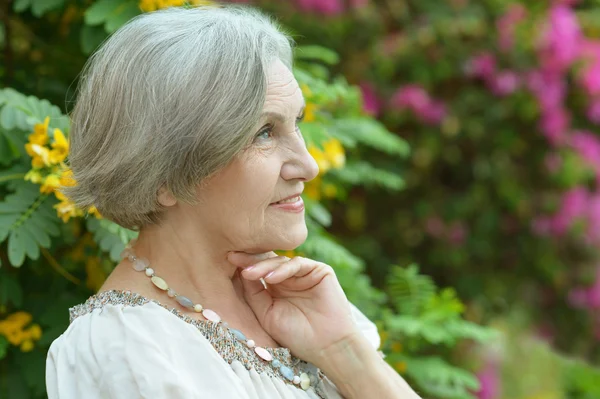 Older woman with flowers — Stock Photo, Image