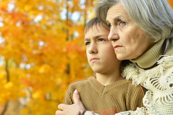 Grandmother with boy  in autumn park — Stock Photo, Image