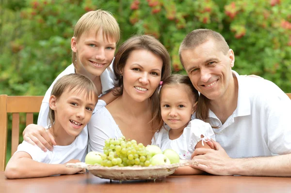 Família comendo frutas à mesa — Fotografia de Stock