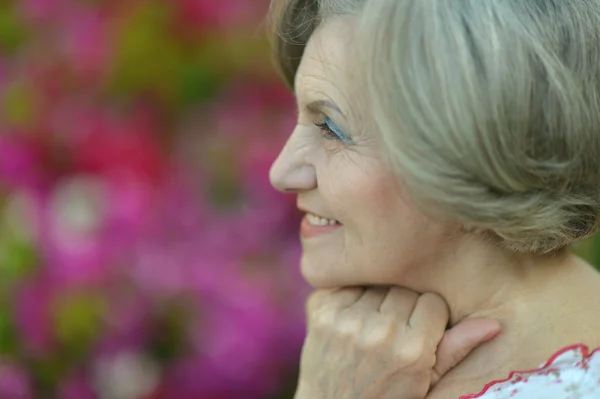 Mujer mayor con flores — Foto de Stock