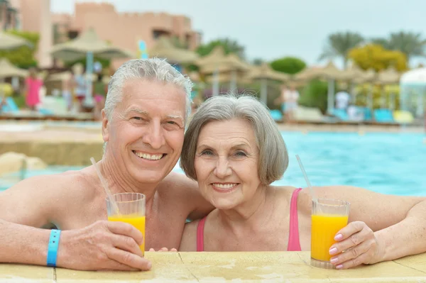Seniorenpaar trinkt Saft im Pool — Stockfoto