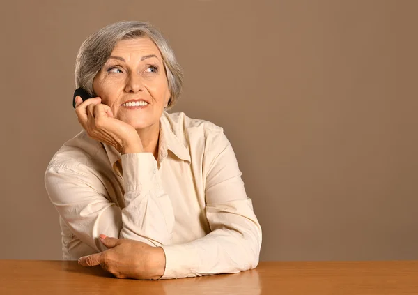 Worried elderly woman speaking on mobile — Stock Photo, Image