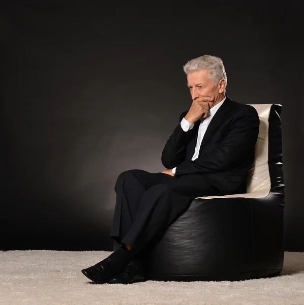 Pensando maturo uomo d'affari seduto sulla sedia — Foto Stock