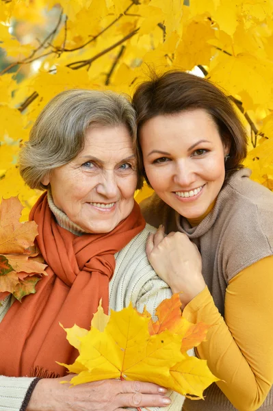 Mother and daughter in autumn park — Stock Photo, Image