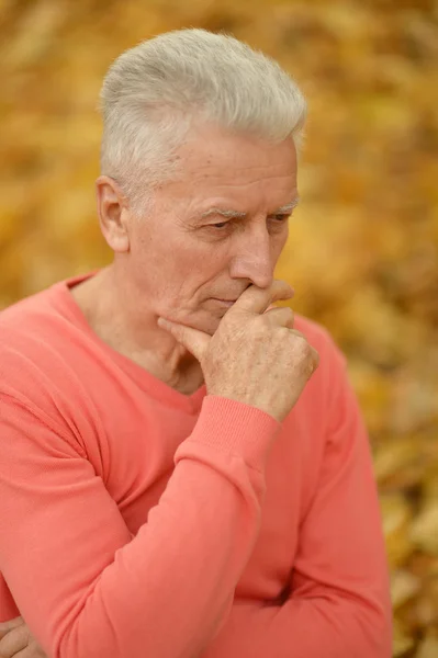 Oudere man op herfst achtergrond — Stockfoto