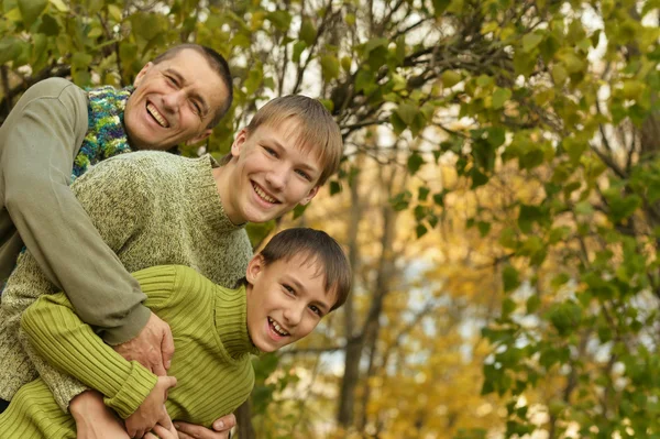 Father and sons in autumn park — Stock Photo, Image