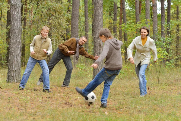 Familj spelar fotboll skog — Stockfoto