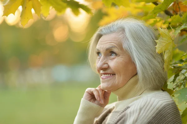 Oudere vrouw in herfstpark — Stockfoto