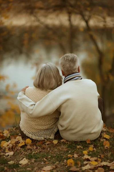 Älteres Paar sitzt am See — Stockfoto