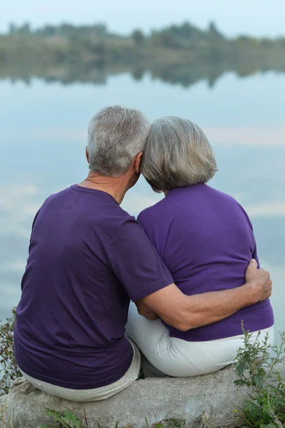 Зріла пара сидить біля озера — стокове фото