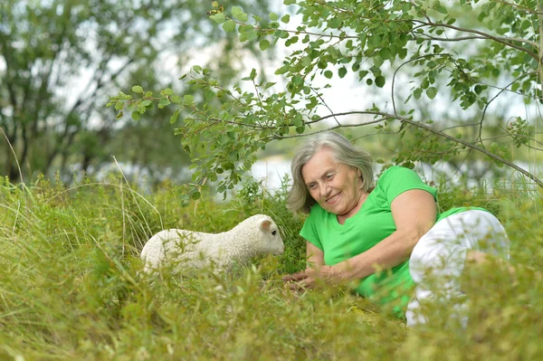 Senior woman   with toy sheep — Stock Photo, Image