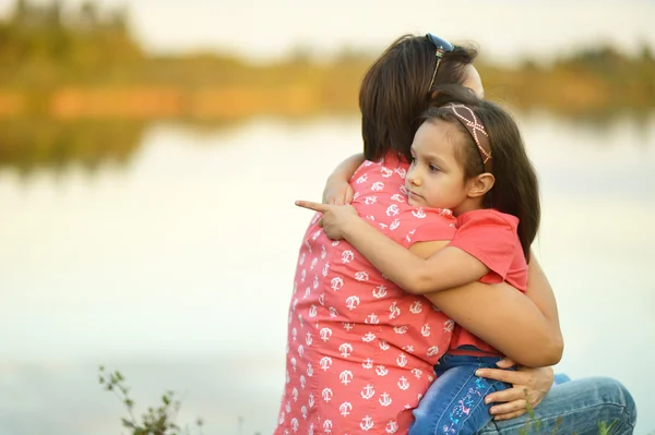 Девушка с матерью у озера — стоковое фото