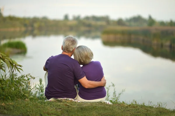 Ouder paar zitten in de buurt van lake — Stockfoto