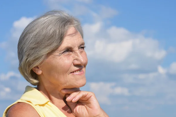 Senior vrouw op achtergrond hemel — Stockfoto