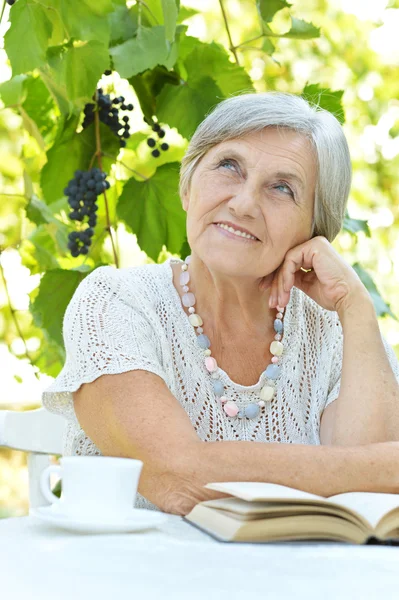 Senior woman in summer at table — Stock Photo, Image