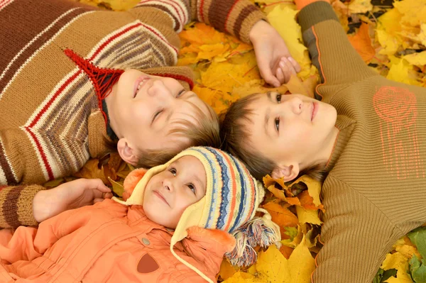 Дети, лежащие на желтых листьях — стоковое фото
