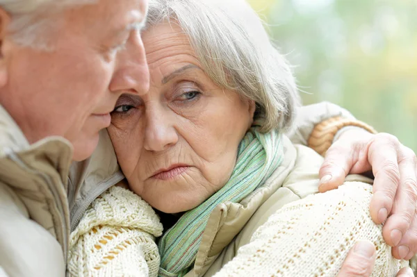 Sad senior couple in autumn park — Stock Photo, Image