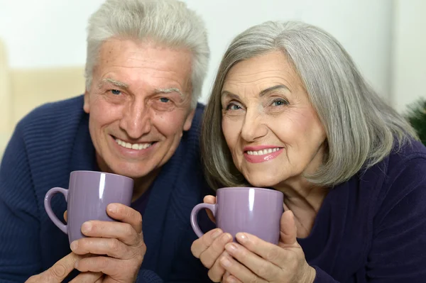 Aged couple with cups — Stock Photo, Image
