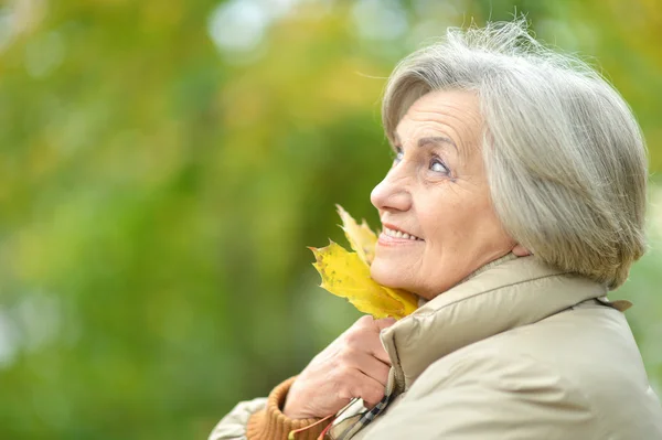 Oudere vrouw in herfstpark — Stockfoto