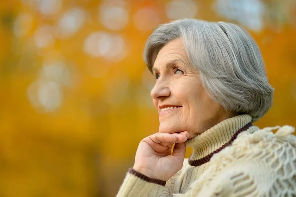 Senior woman in autumn park — Stock Photo, Image