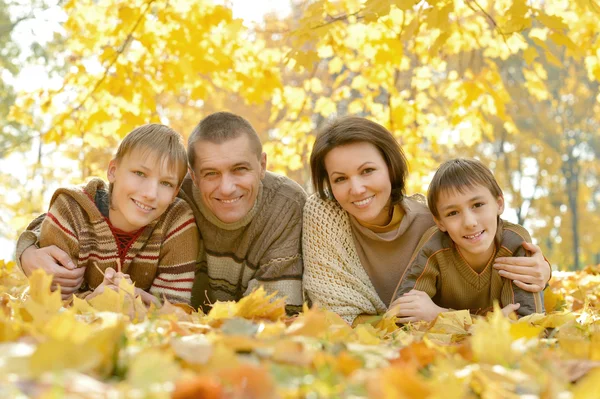 Família feliz deitado no parque de outono — Fotografia de Stock