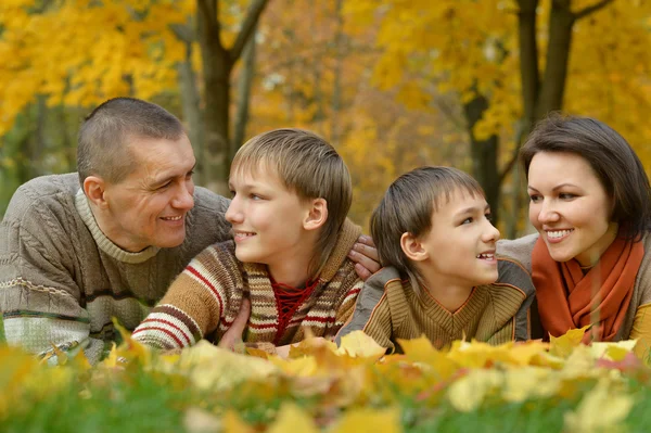 Familia feliz acostada en el parque de otoño — Foto de Stock