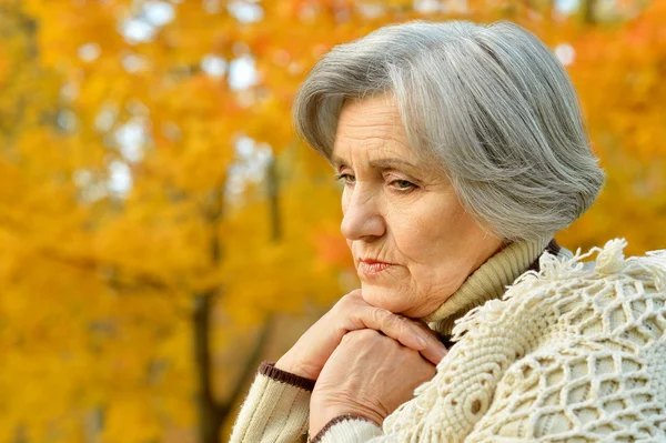 Thoughtful senior woman in autumn — Stock Photo, Image