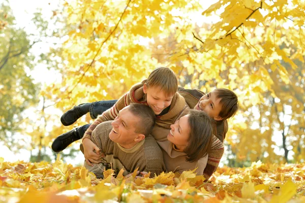 Счастливая семья лежит в осеннем парке — стоковое фото